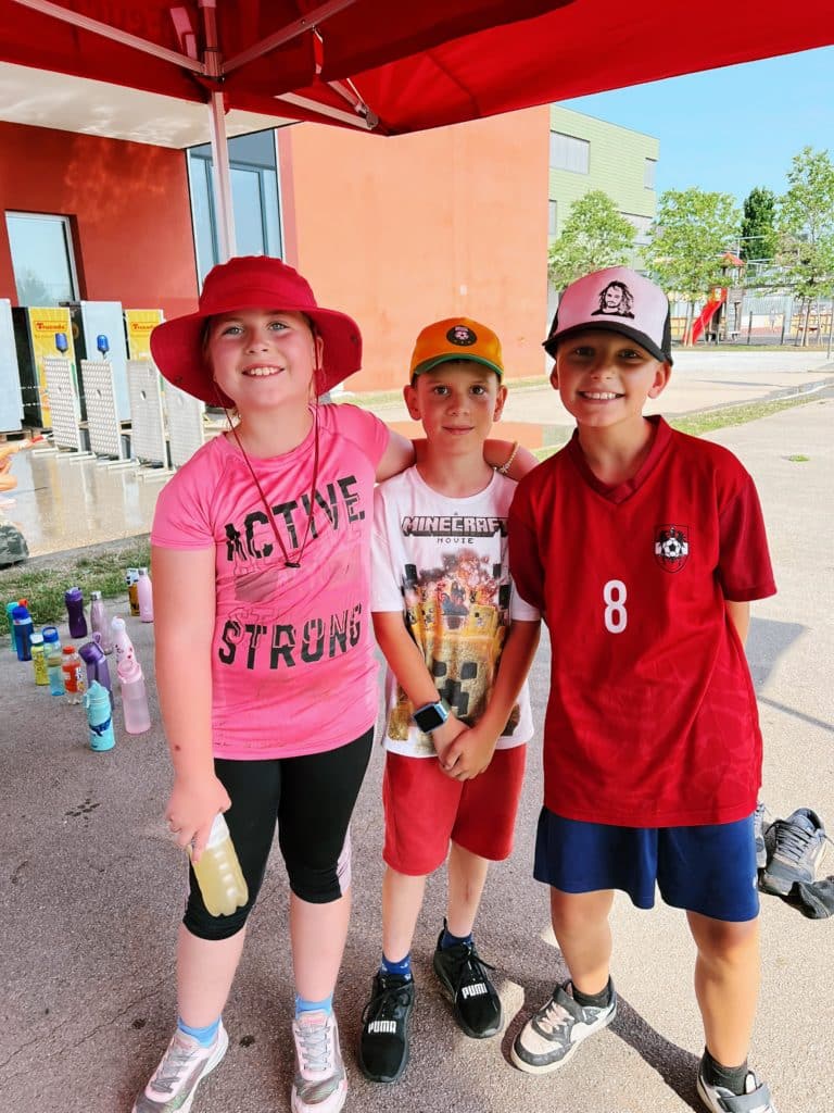 Feuerwehr Zettling beim Schulsportfest der Volksschule Premstätten 2025 – Kübelspritzen-Station mit Erinnerungsbuttons und Jugendfolder für die Kinder