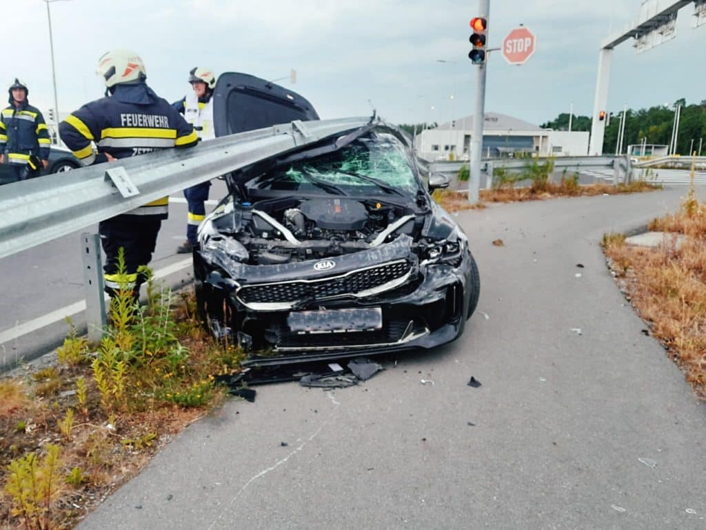 Einsatzkräfte der Feuerwehr Zettling beim Verkehrsunfall-Einsatz – PKW unter Leitplanke, verletzte Person vom Roten Kreuz versorgt