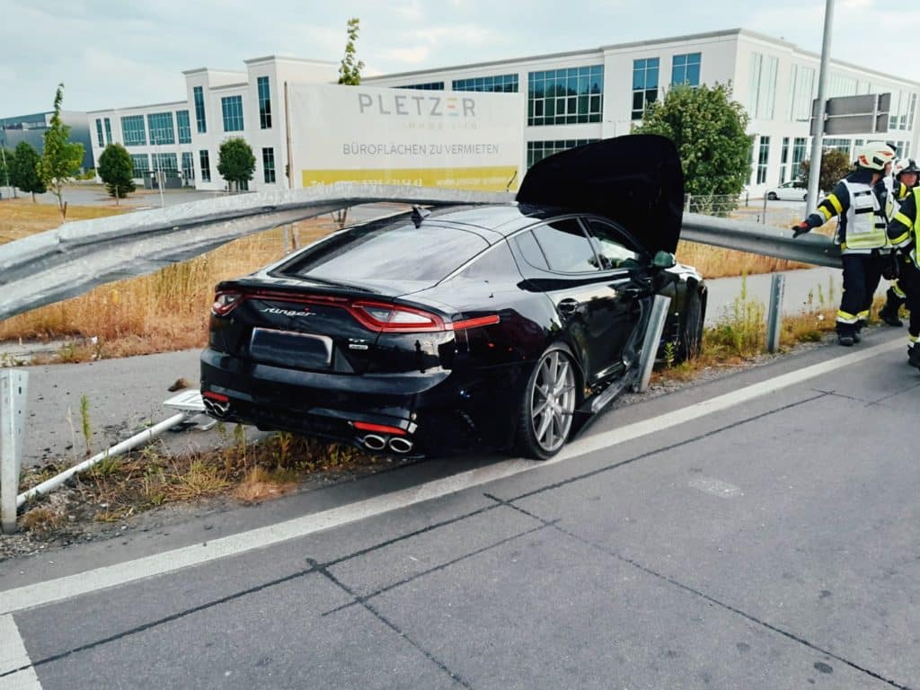 Einsatzkräfte der Feuerwehr Zettling beim Verkehrsunfall-Einsatz – PKW unter Leitplanke, verletzte Person vom Roten Kreuz versorgt