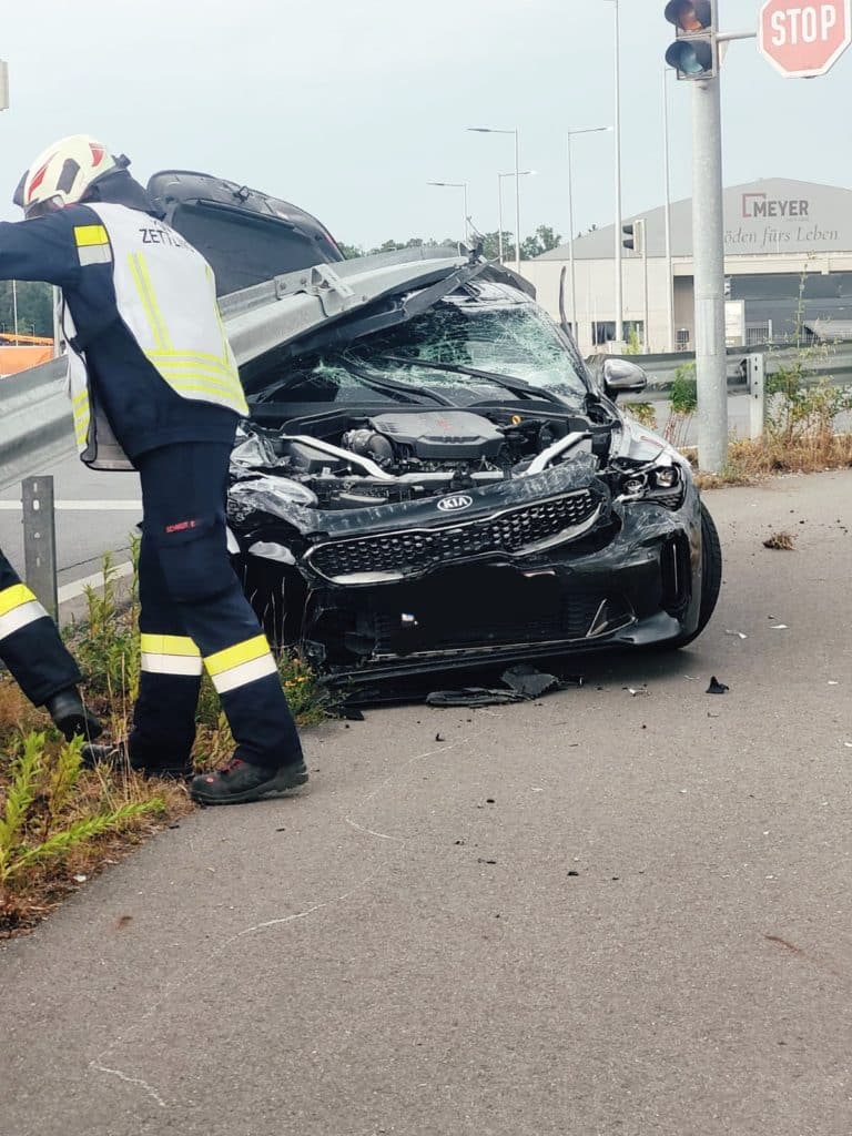 Einsatzkräfte der Feuerwehr Zettling beim Verkehrsunfall-Einsatz – PKW unter Leitplanke, verletzte Person vom Roten Kreuz versorgt